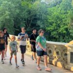 Grupo de viajeros cruzando Bow Bridge en Central Park