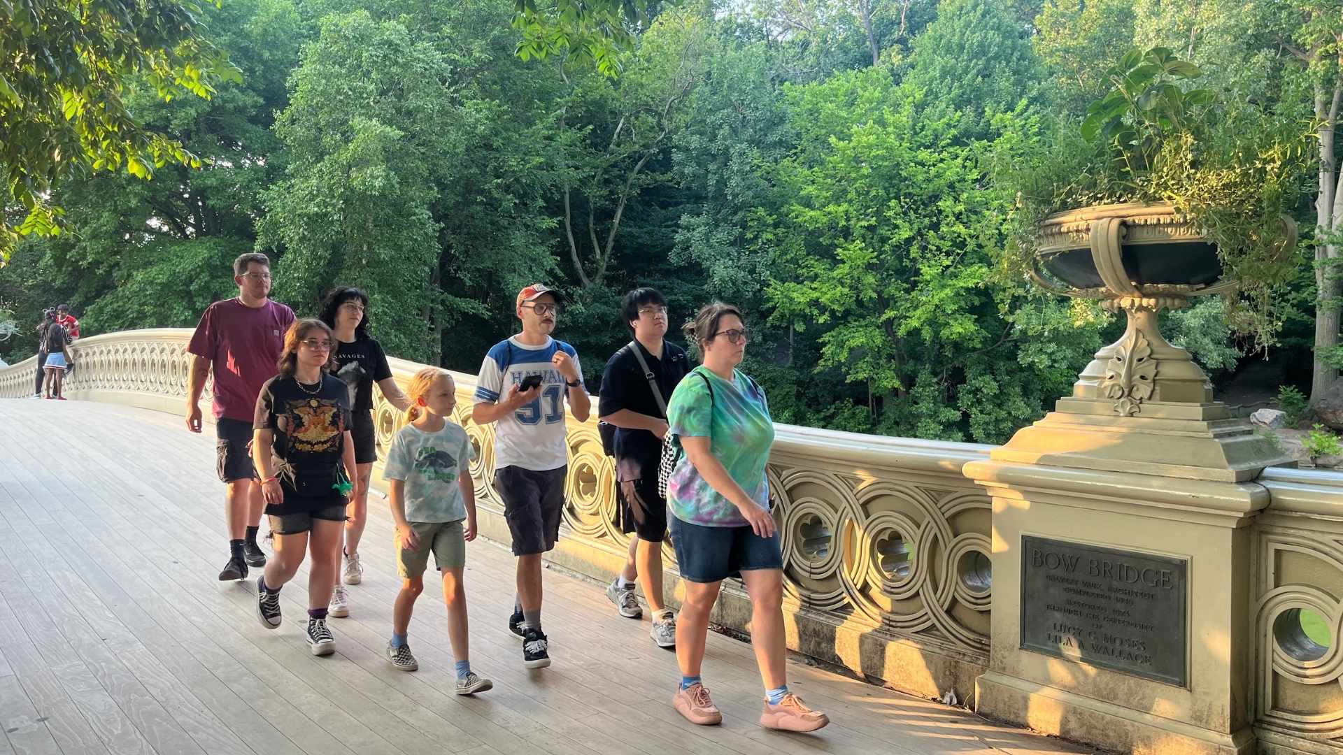Grupo de viajeros cruzando Bow Bridge en Central Park