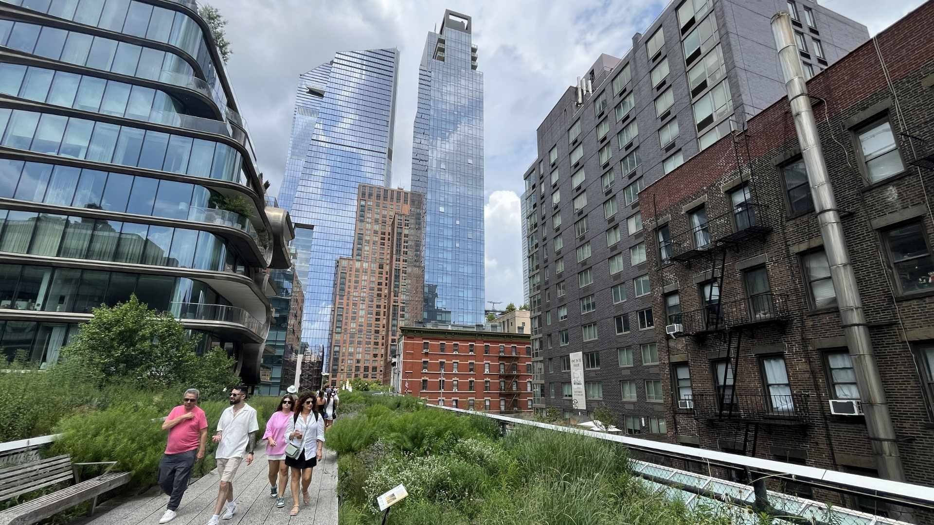Personas caminando por la High Line con edificios de Hudson Yards al fondo