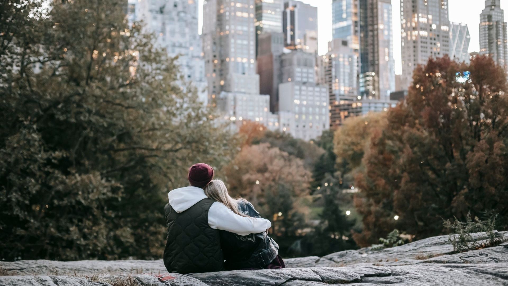 Pareja abrazada en Central Park con los rascacielos de Manhattan al fondo