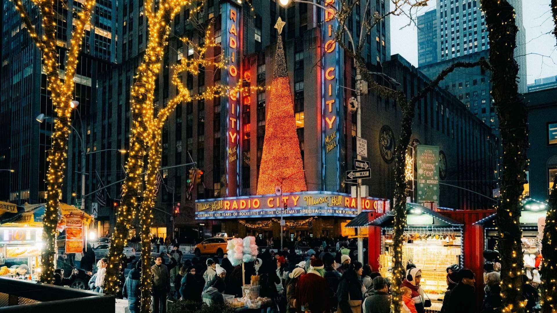 Fachada de Radio City Music Hall con decoración navideña y puestos en la calle