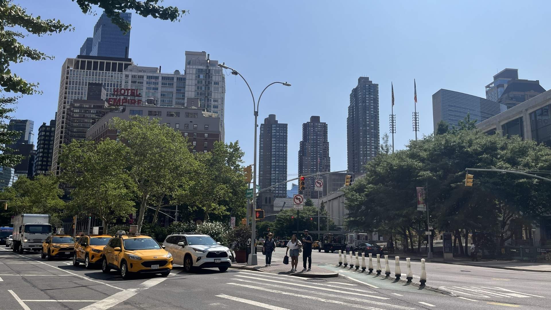 Cruce de Manhattan con varios taxis amarillos y edificios al fondo